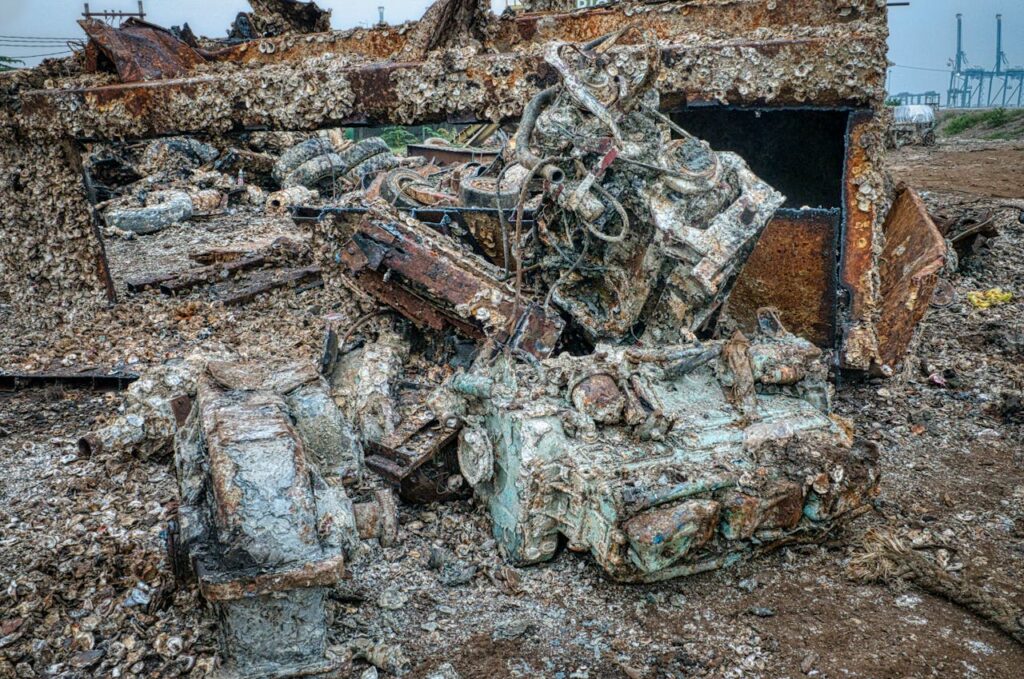 A detailed view of rusted machinery and debris at a junkyard in Jakarta, Indonesia.